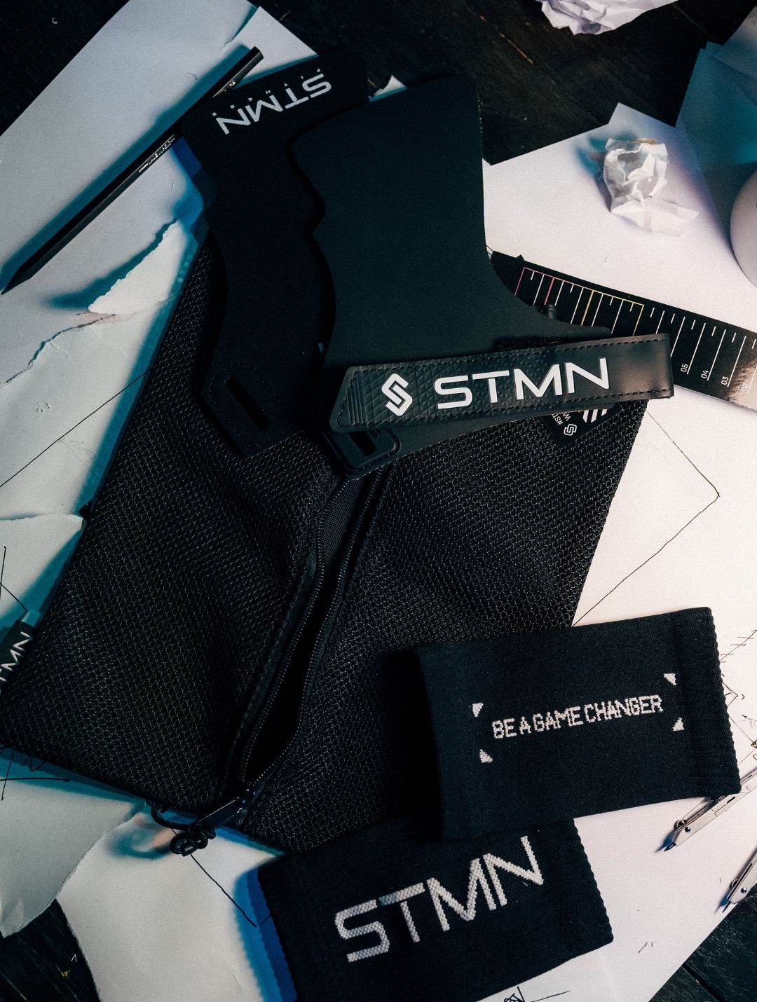 Flatlay paracalli Hybrid STMN Fitness con sacchetto in mesh e polsini in omaggio su scrivania da progetto